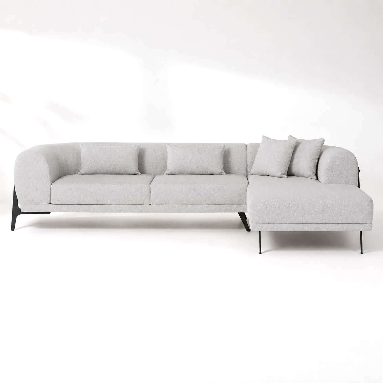 Γωνιακός καναπές ΟΡΟ σε light grey υφασμάτινη επένδυση με ανάκλινδρο, στρογγυλεμένα μπράτσα, μεταλλικά πόδια και μεταλλική λεπτομέρεια στην πλάτη σε λευκό φόντο.
