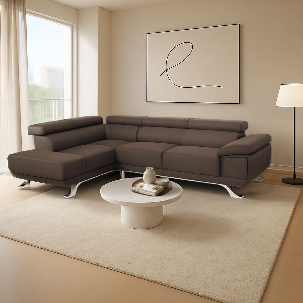 Ένας κομψός, καφέ δερμάτινος γωνιακός καναπές με δεξιά γωνία (σεζλόνγκ) και μοντέρνα πόδια με φινίρισμα χρωμίου. Βρίσκεται σε ένα φωτεινό, μίνιμαλ σαλόνι με ανοιχτόχρωμο ξύλινο πάτωμα, ένα μεγάλο παράθυρο, ένα λιτό λευκό τραπεζάκι σαλονιού με κεντρική βάση και ένα κάδρο με αφηρημένη γραμμική τέχνη. / Brown