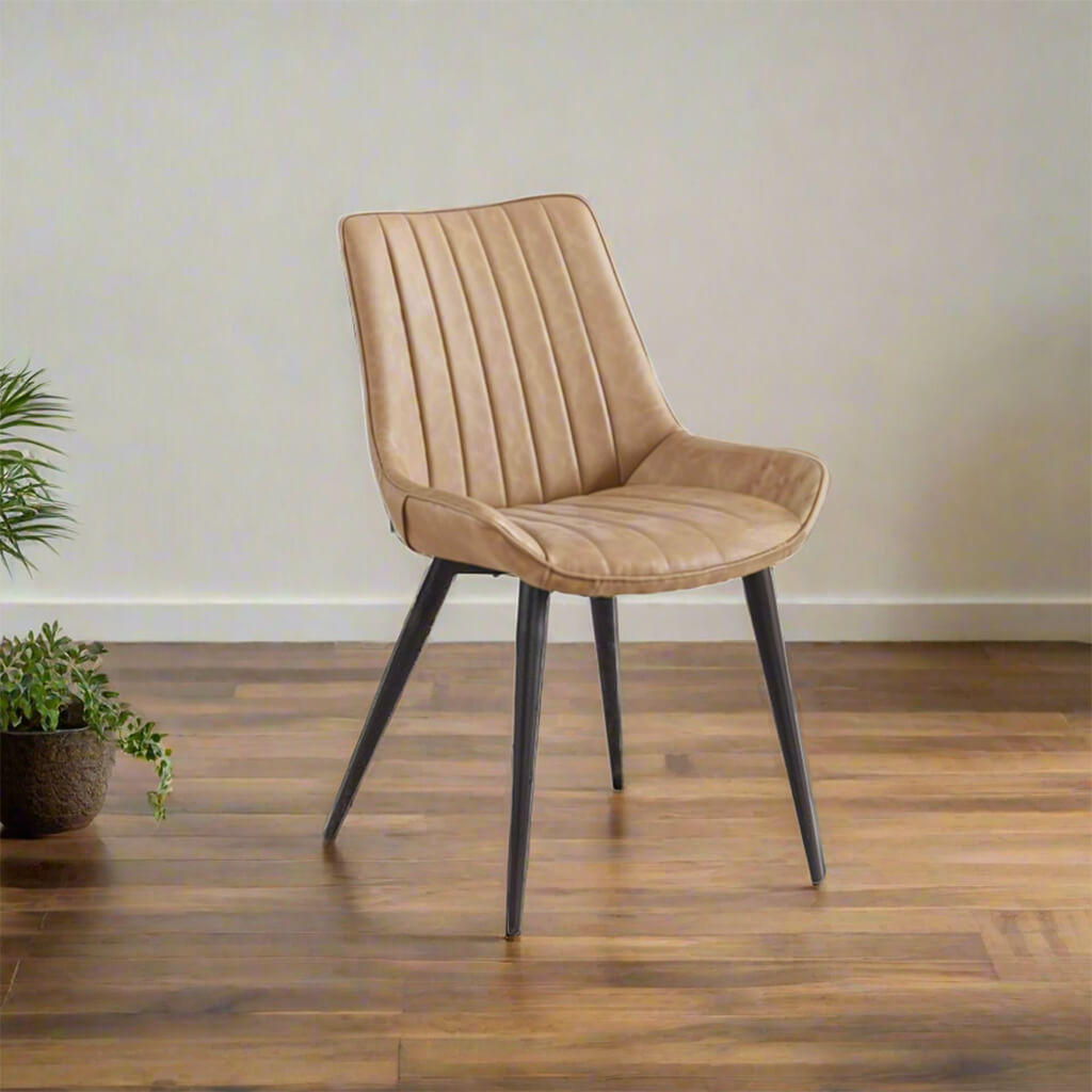 Μοντέρνα καρέκλα τραπεζαρίας με ταπετσαρία από PU σε καμηλό χρώμα, κάθετες ραφές (καπιτονέ) και μαύρα μεταλλικά πόδια από ατσάλι.