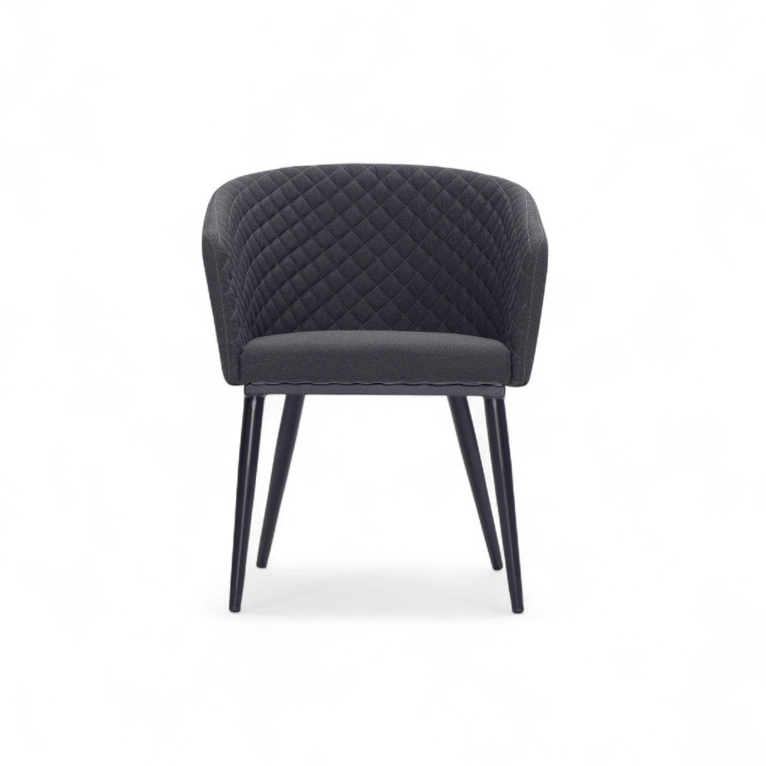 Μπροστινή όψη της καρέκλας τραπεζαρίας Lisbon, αναδεικνύοντας το καπιτονέ εσωτερικό και το σχέδιο που αγκαλιάζει το σώμα.