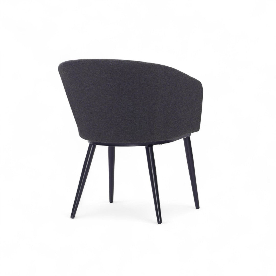 Πίσω όψη της καρέκλας τραπεζαρίας Lisbon, που δείχνει την καμπυλωτή πλάτη και τα μαύρα μεταλλικά πόδια της.