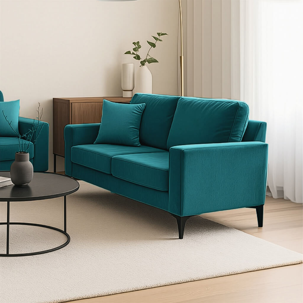 Ένας μοντέρνος διθέσιος καναπές σε πλούσιο τυρκουάζ χρώμα, τοποθετημένος σε ένα σύγχρονο σαλόνι. Ο καναπές διαθέτει λεπτά μαύρα πόδια και βρίσκεται πάνω σε ένα μπεζ χαλί, δίπλα σε ένα στρογγυλό μαύρο τραπεζάκι σαλονιού και έναν ξύλινο μπουφέ στο φόντο. / Turquoise