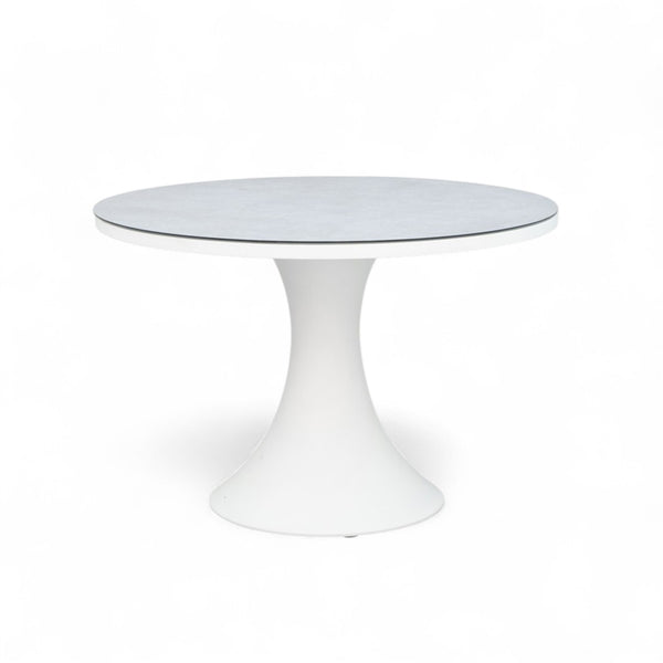 שולחן חוץ עגול Camilla עם בסיס pedestal אייקוני, מבודד על רקע לבן.