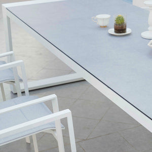Detail of the surface of the Linz garden table, showing the matte glass finish over the white aluminium frame.