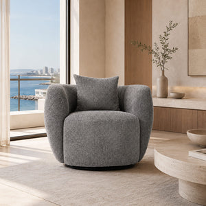 Περιστρεφόμενη πολυθρόνα RAFAELLO Grey σε γκρι textured ύφασμα με στρογγυλεμένα μπράτσα και μαξιλάρι σε φωτεινό σαλόνι.