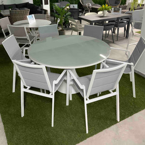 פינת אוכל עגולה לגן Camilla/Luca, עם שולחן pedestal וכיסאות Quick Dry, באולם תצוגה.