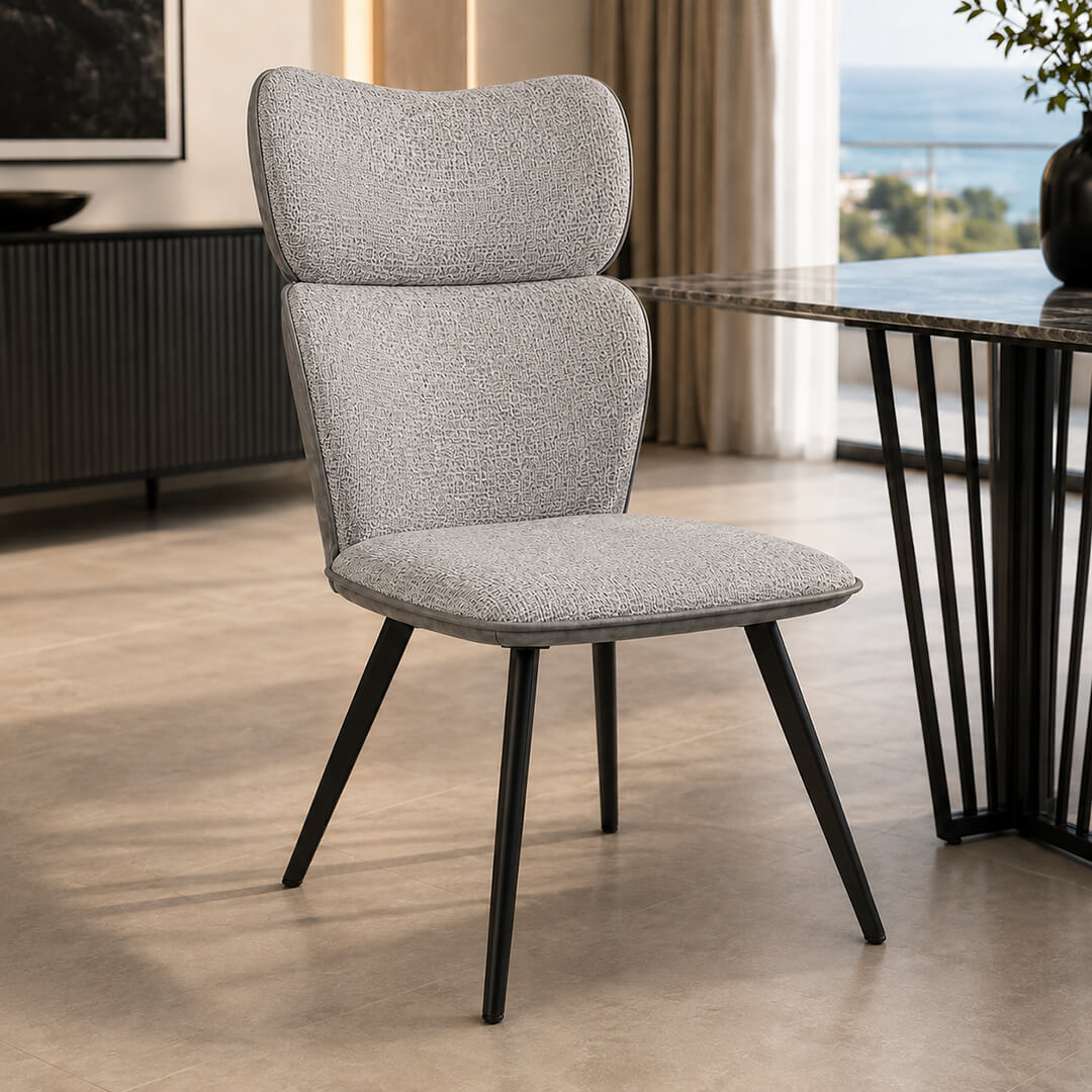 Καρέκλα VITRA σε light grey ύφασμα με ψηλή πλάτη και μαύρα πόδια τοποθετημένη δίπλα σε μοντέρνο τραπέζι.