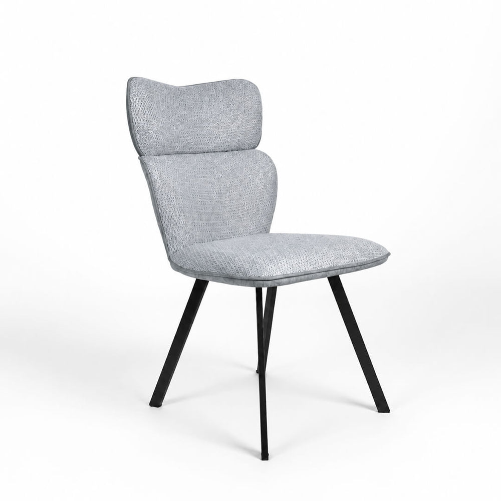 Стул VITRA из светло-серой ткани с высокой спинкой и чёрными ножками, рядом с современным столом.