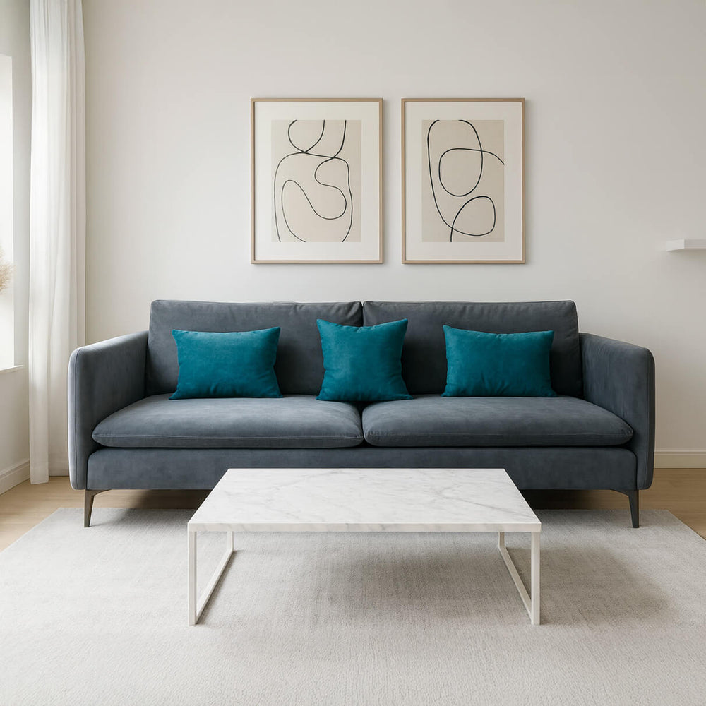 Three-seater living room sofa in grey, with turquoise cushions and silver legs.