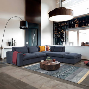 Modern Lagun corner sofa in a dark grey-blue colour, with plush cushions and wide arms. / Blue grey