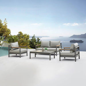 Armani outdoor seating set with a dark grey powder-coated metal frame and light grey synthetic leather cushions, including two armchairs, a two-seater sofa and a rectangular coffee table, set on a white terrace with a sea view and dense greenery. - Lux Furniture