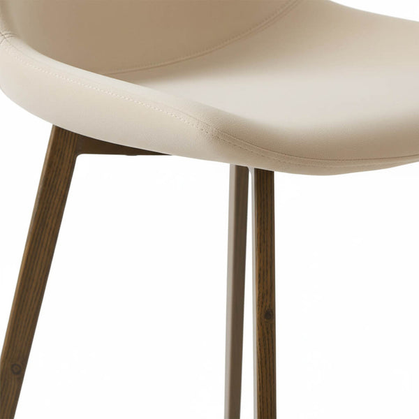 Close-up of the beige seat and legs of the BS bar stool